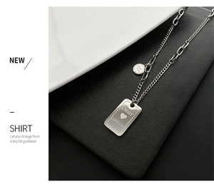 Macro detail of titanium steel necklace with engraved Dear Love You rectangular pendant