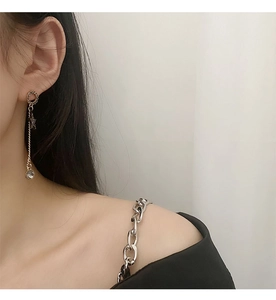 Detail of elegant gold star tassel earrings featuring crystal charms on a model