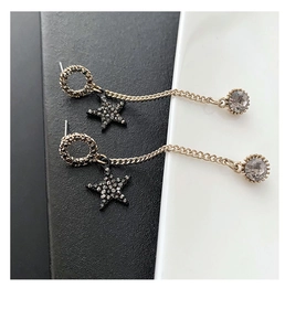 Detail of long star tassel earrings featuring black star charms and drop crystals