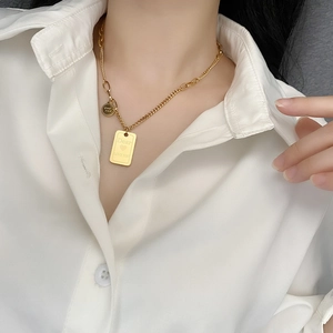 Gold titanium steel layered necklace with square and round pendants worn by a model