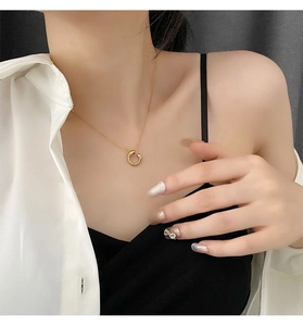 Elegant gold geometric circle pendant necklace worn by a model on a delicate thin chain