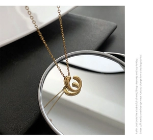 Macro detail of golden spiral pendant with mirror reflection on black leather