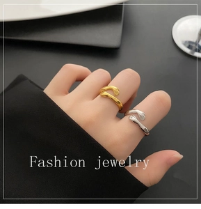Detailopname van verstelbare knuffel ring in goud en zilver op de hand gedragen