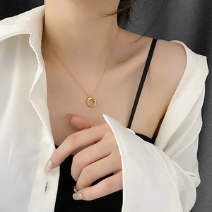 Gold plated geometric circle necklace on model wearing a white shirt and black top