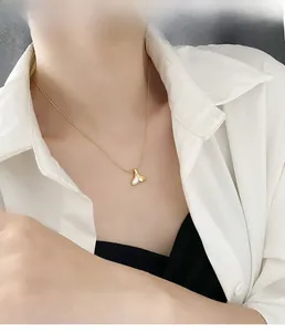 Dettaglio di una collana a coda di sirena dorata con intarsio in madreperla bianca