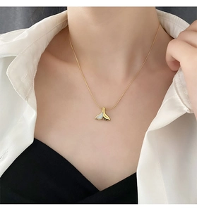 Dettaglio della collana a coda di sirena in titanio con madreperla bianca sul collo