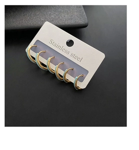 Detalle de 5 pares de pendientes de aro de acero inoxidable dorado con esmalte azulado