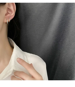Primer plano de pendientes de aro minimalistas en esmalte azul claro en una modelo