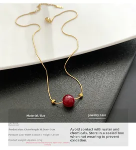 Detail of red bead pendant on gold titanium steel snake chain showing 39.7cm length