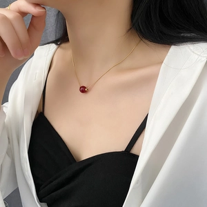 Minimalist titanium steel necklace with red bean bead pendant on gold snake chain
