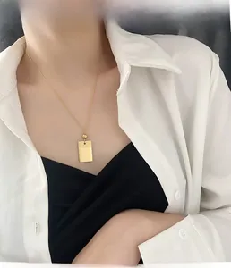 Macro di una collana con pendente rettangolare dorato con doppia finitura testurizzata