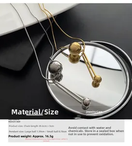 Vue détaillée de colliers en acier titane avec sphères métalliques sur miroir poli