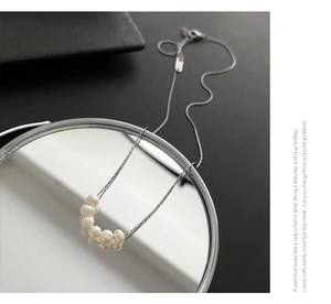 Detailed view of freshwater pearl pendant necklace reflected on a clean mirror edge