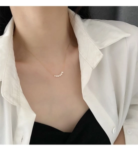 Close-up of minimalist titanium steel necklace featuring five natural freshwater pearls
