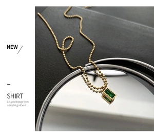 Macro di un ciondolo con smeraldo taglio rettangolare su catena a sfere dorata