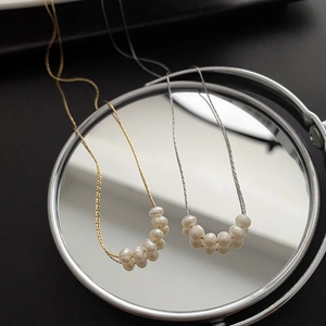 Elegant natural freshwater pearl necklaces in gold and silver finish on a mirror