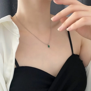 Elegante collana con ciondolo di smeraldo in oro 18 carati indossata da una modella su catena