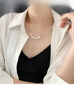 Collier élégant en titane doré avec 8 perles blanches rondes porté sur un mannequin