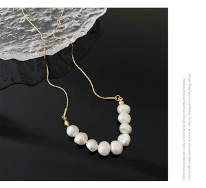 Détail macro de perles baroques sur un collier pour femme en acier titane doré