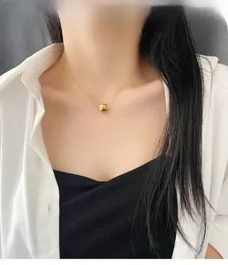 Macro shot of 18K gold-plated geometric faceted cylinder pendant on a dainty chain