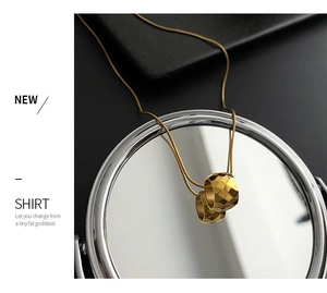 Detailed view of 18K gold titanium steel necklace with diamond-cut cylinder pendants