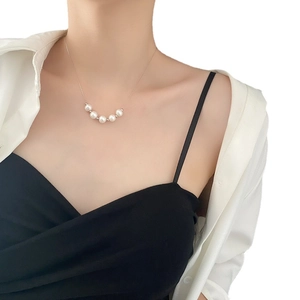 Collier minimaliste en acier titane avec cinq perles blanches et accents dorés