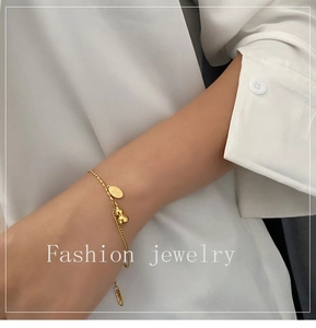 Detailed view of 18k gold plated gourd pendant on a dainty mixed chain bracelet