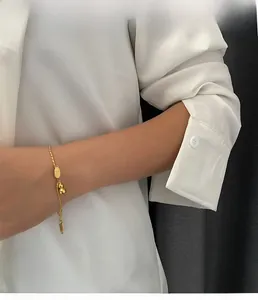 Lifestyle shot of 18k gold gourd pendant bracelet worn on a woman's wrist