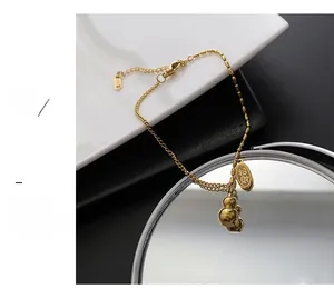 Close-up of golden double-chain bracelet with gourd charm and Zhaocai engraving