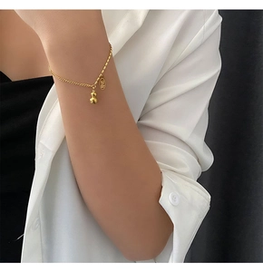 Detail of 18k gold plated titanium bracelet with lucky gourd charm and engraved tag