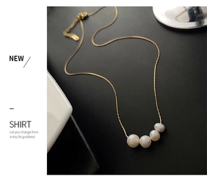 Detail of minimalist gold snake chain necklace with four gradient natural pearls