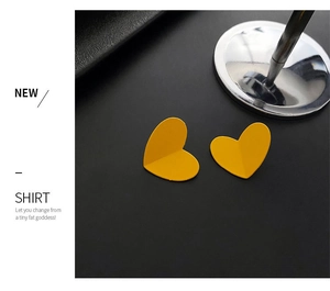 Detail view of stylish yellow heart earrings with premium matte paint texture finish