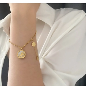 Detail von 18K Gold Armband mit Schaukelpferd Anhänger und Perlmutt auf Modell