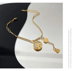 Detail eines 18K vergoldeten Pferde-Charm-Armbands mit Perlmutt- und Dollarzeichen-Anhängern