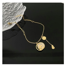 Detail eines 18K vergoldeten Armbands mit Perlmutt-Pony und Geld-Anhängern