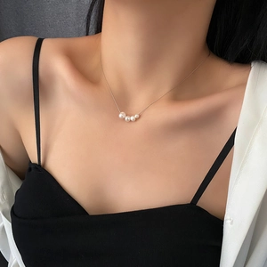Elegant titanium steel necklace featuring four graduated natural pearls on a gold chain