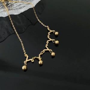 Minimalist crown style titanium anklet with gold beads shown at a 45-degree angle