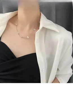 Detail of crystal beaded necklace with silver chain on model wearing a white shirt