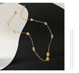 Detailed shot of gold titanium necklace featuring iridescent crystal cubes and clasp