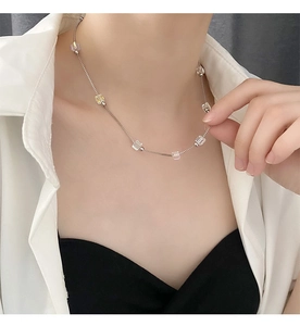 Detail of beaded necklace with clear square crystals on a fine silver steel chain
