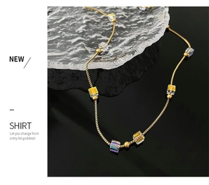 Close-up of golden box chain necklace with aurora crystal cubes and metallic beads
