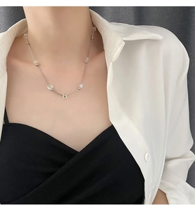 Close-up of crystal bead necklace on model featuring shimmering cubes and titanium steel chain