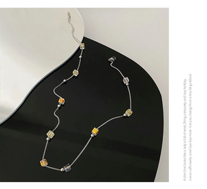 Detailed shot of long titanium steel necklace featuring colorful cubic crystal beads