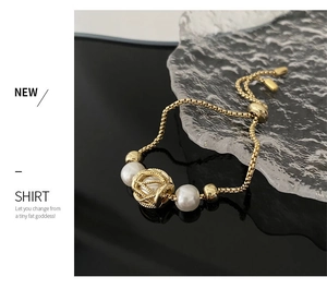 Detail of adjustable gold pearl bracelet with box chain and hollow engraved beads