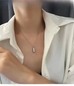Détail du pendentif goutte d'argent sur mannequin montrant le design minimaliste