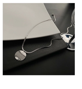 Vue détaillée du collier en acier titane argenté avec un pendentif Dreaming D
