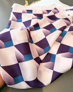 Gros plan détaillé sur la texture soyeuse et l'imprimé géométrique de ce foulard chic