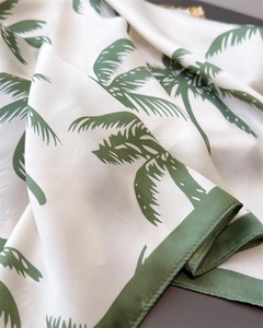 Macro view of silky texture and palm leaf print on elegant summer square scarf