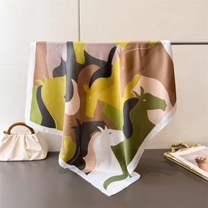 Detail of silk-like scarf with abstract horse patterns and elegant contrast stitching