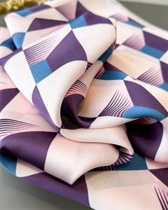Détail d'un foulard en soie synthétique aux motifs géométriques et texture soyeuse